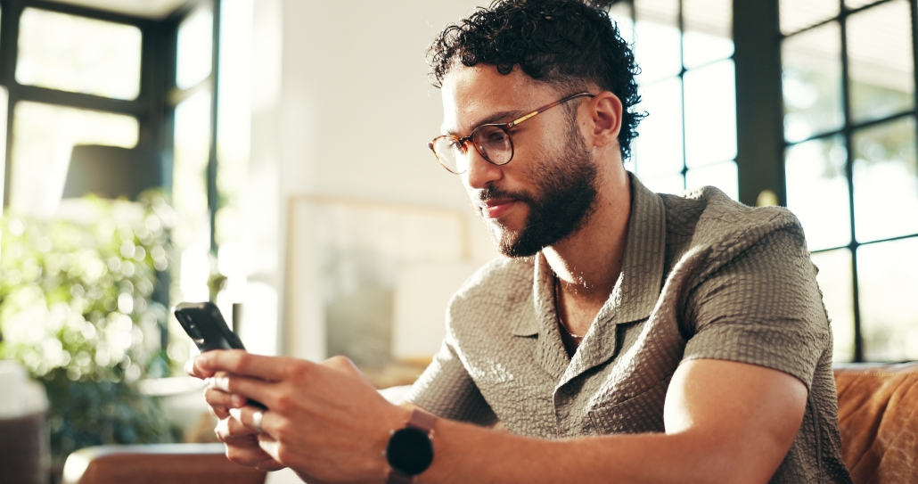 man in glasses looking at phone